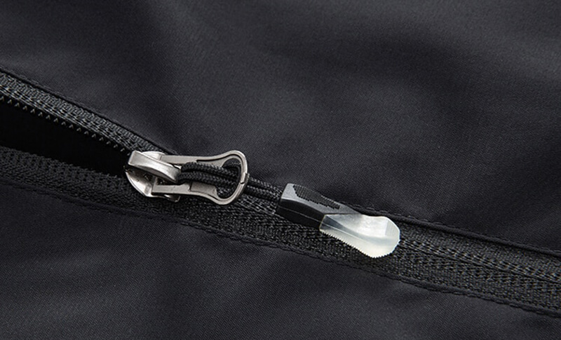 Close-up of black sports men's jacket zipper with reflective strips for visibility.
